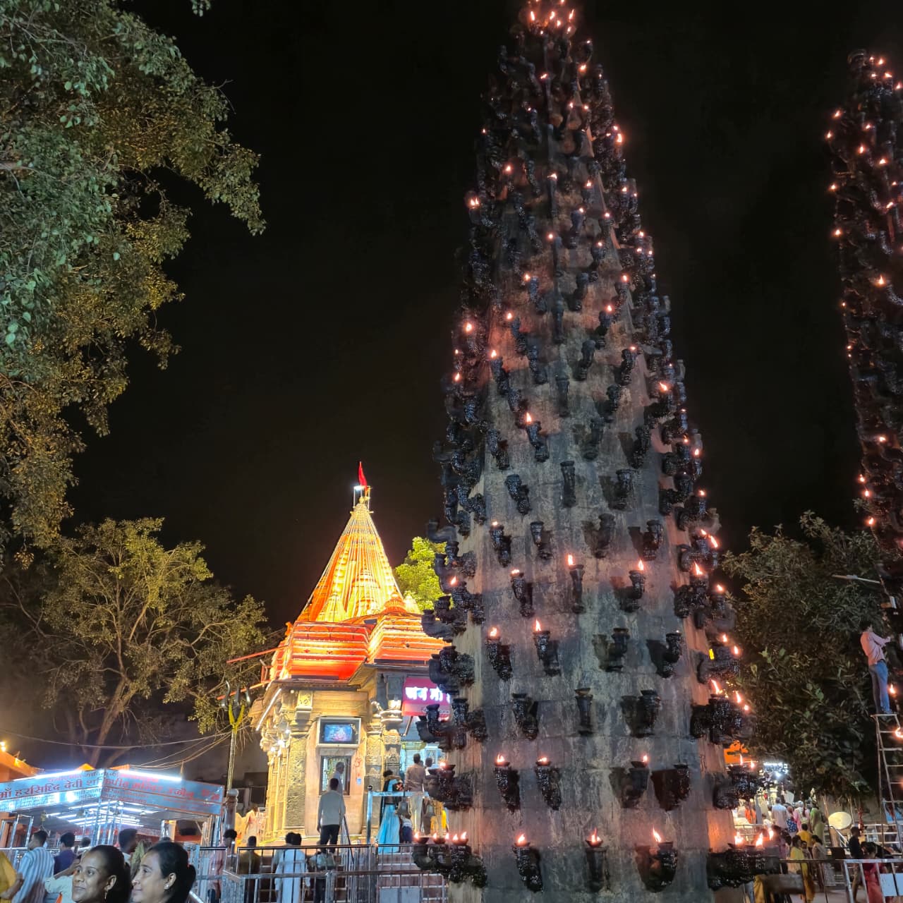 Deep stambh lamp tower lit with oil lamps beside Shree Harsiddhi Mata Shaktipeeth, Ujjain, at night