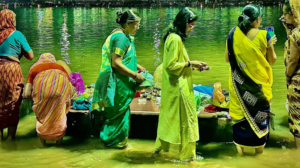 Women devotees standing in the Shipra at Ram Ghat with diyas for deepdaan, Ujjain