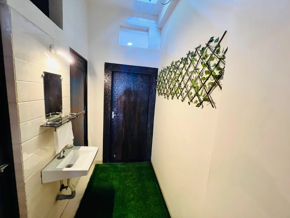 Hallway with green turf mat and leaf wall art at AP Suite, AP Villas Ujjain
