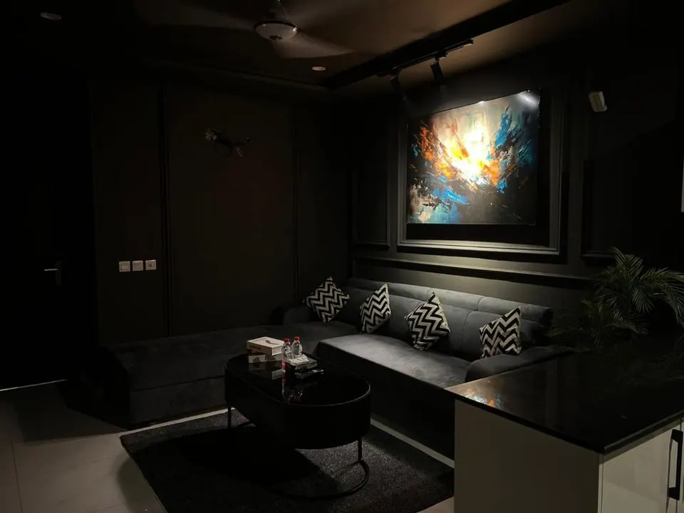 Lounge with dark interiors and wall art at Om Shanti Stay, AP Villas Ujjain