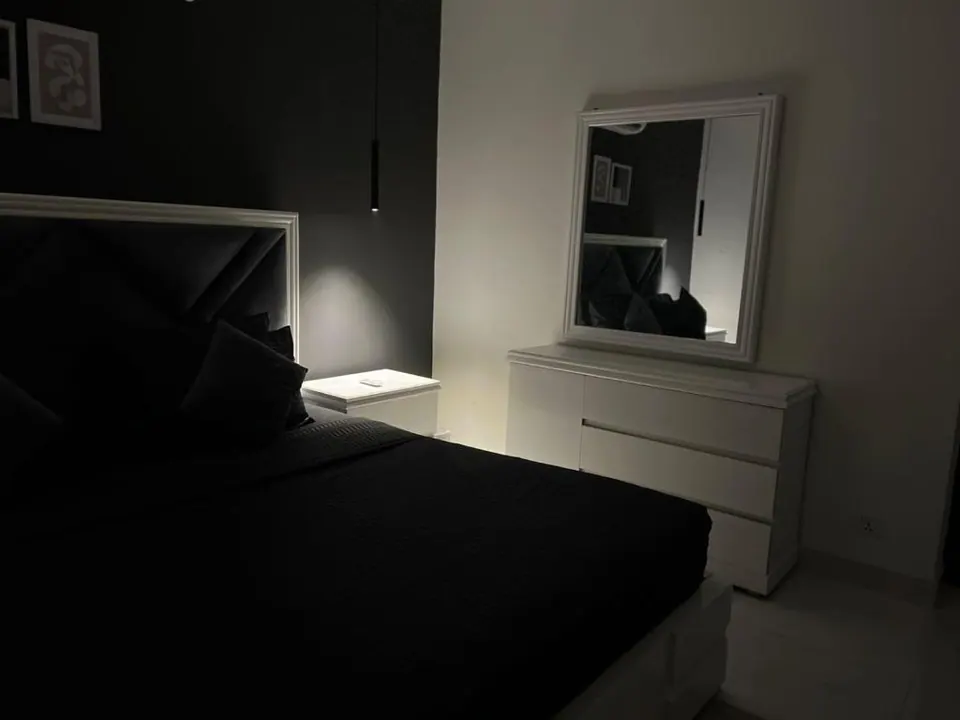 Bedroom with dark interiors at Om Shanti Stay, AP Villas Ujjain