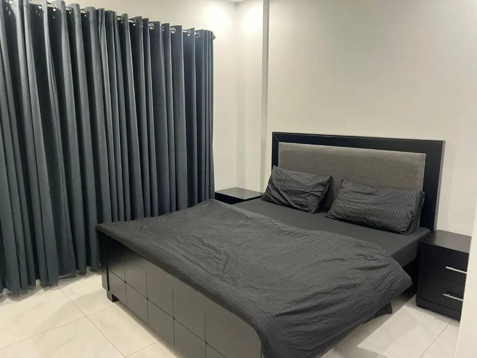 Bedroom with grey bedding at Om Shanti Stay, AP Villas Ujjain