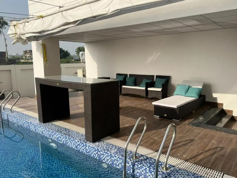 Pool deck with lounge seating at Om Shanti Stay, AP Villas Ujjain