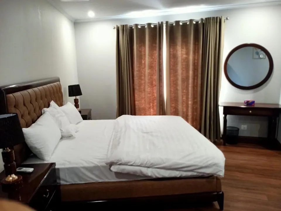 Bedroom with double bed and round mirror at Villa Aranya, AP Villas Ujjain