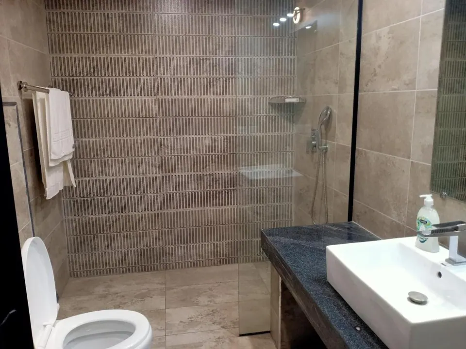 Bathroom with stone-tile walls at Villa Aranya, AP Villas Ujjain